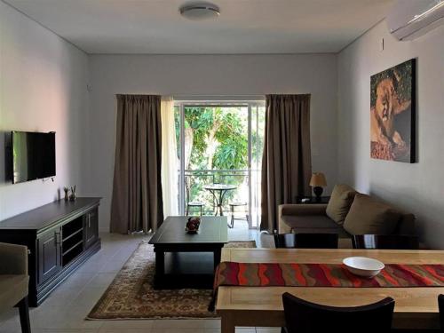 - un salon avec un canapé et une table dans l'établissement Apartments @ 125, à Gaborone
