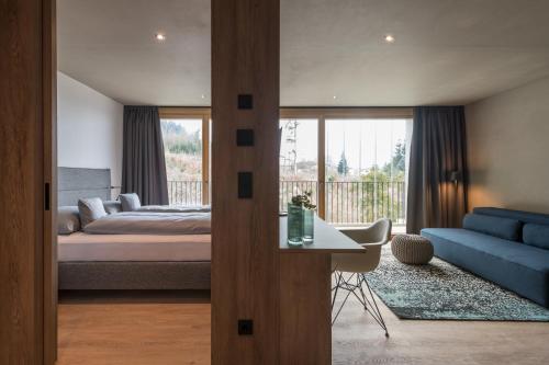 a bedroom with a bed and a blue couch at Livingreen Residences in Feldkirch