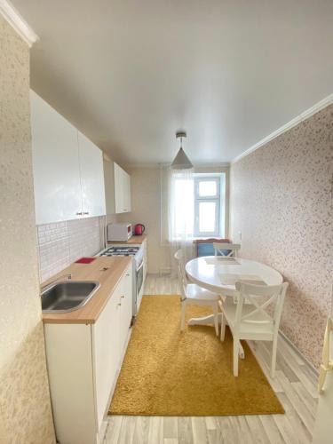 uma cozinha com uma mesa e uma mesa e cadeiras em 2-х комнатная квартира напротив аквапарка em Aqtöbe