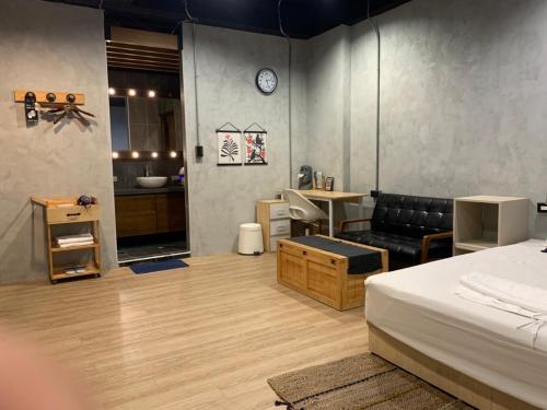 a bedroom with a bed and a desk and a kitchen at Wuhoo House in Kaohsiung