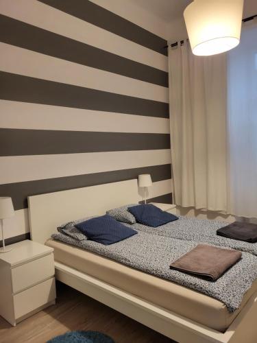 een slaapkamer met een bed met blauwe kussens bij Apartament Vistula in Krakau