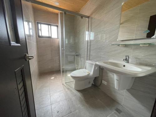 La salle de bains est pourvue de toilettes, d'un lavabo et d'une douche. dans l'établissement Wind Island B&B, à Hsing-wen