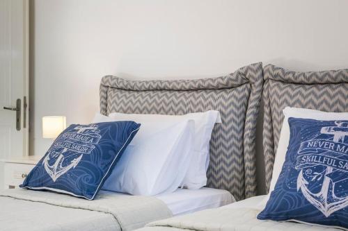 a bed with blue and white pillows on it at Absolute View in Kefallonia