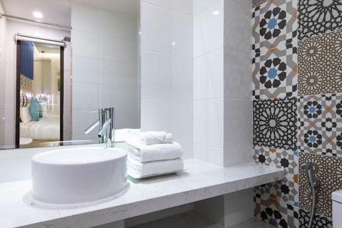 Bella Merry Hotel and Apartment في دا نانغ: حمام أبيض مع حوض ومرآة