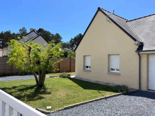 a house with a tree in the front yard at Le 4 Maison de charme proche de la plage wifi in Barneville-Carteret