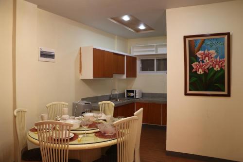 a kitchen with a table and chairs in a room at Anicia Guesthouse Rooms in Manila