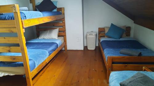 a room with three bunk beds and a staircase at Dumela Margate Flat No 30 in Margate