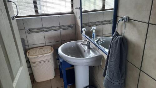 a small bathroom with a sink and a window at Dumela Margate Flat No 30 in Margate