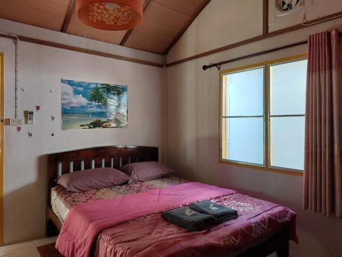- une chambre avec un lit avec des draps roses et une fenêtre dans l'établissement Thong Family Homestay Chiangdao, à Chiang Dao