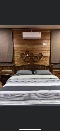 a large bed with a wooden headboard at บ้านสวนรดา baansuanrada in Ban Wang Hom