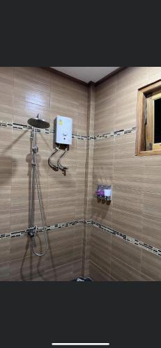 a corner of a bathroom with a hair dryer on a wall at บ้านสวนรดา baansuanrada in Ban Wang Hom