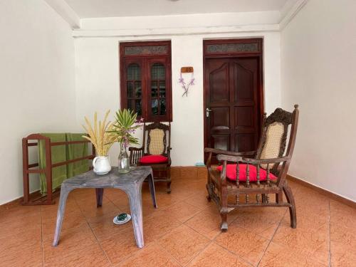 Pokój z krzesłami, stołem i drzwiami w obiekcie Lavila beach cottage w mieście Wadduwa