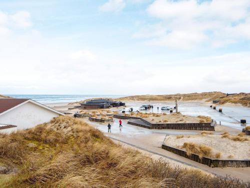 a beach with people walking on the sand at 10 person holiday home in Henne in Henne