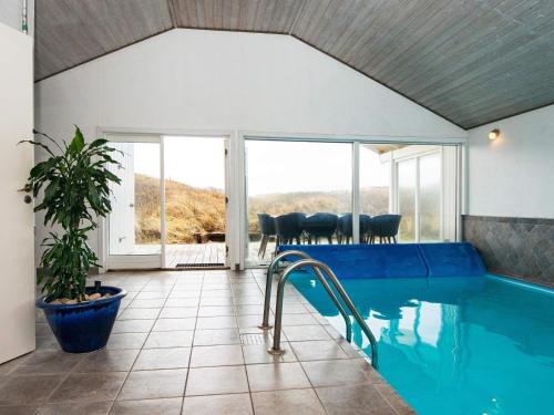 a house with a swimming pool and a patio at 10 person holiday home in Henne in Henne