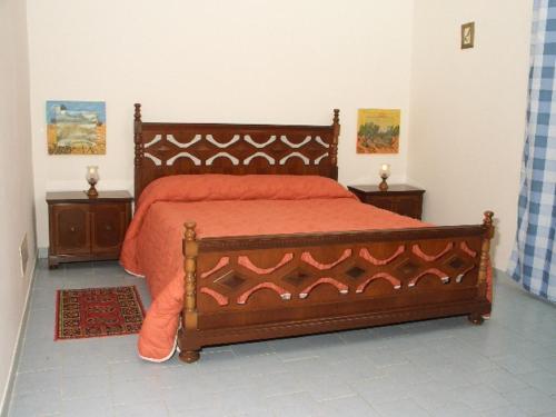 a bedroom with a bed with an orange bedspread at Agriturismo Ruvitello in Misterbianco