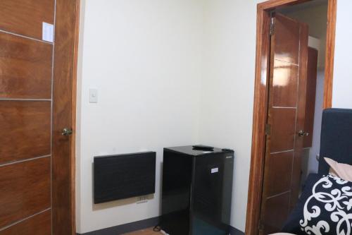 a small room with a television and a door at Anicia Guesthouse Rooms in Manila