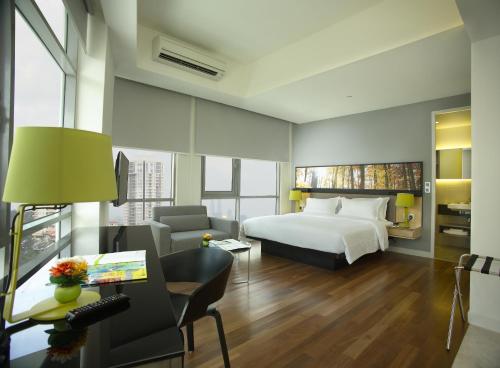 a hotel room with a bed and a desk with a computer at The Signature Hotel & Serviced Suites Kuala Lumpur in Kuala Lumpur