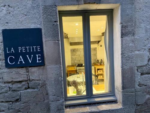 a store window with a sign that reads la petite cave at La Petite Cave in Saignon