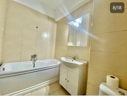 ein Badezimmer mit einer Badewanne, einem Waschbecken und einem WC in der Unterkunft Apartament vedere la mare in Mamaia