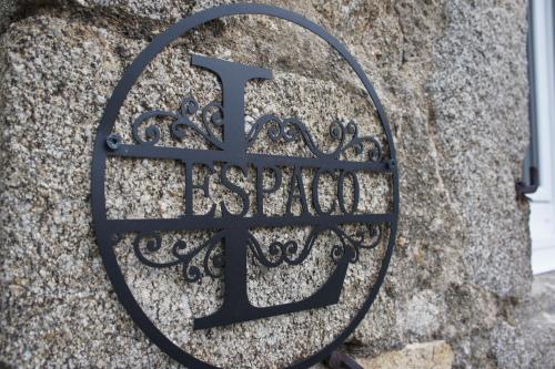 una señal de metal en el costado de una pared de piedra en L'espaco, en Saint-Jeure-dʼAy