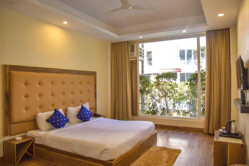 1 dormitorio con cama grande y ventana grande en Avenue 18 Resort, en Rishīkesh
