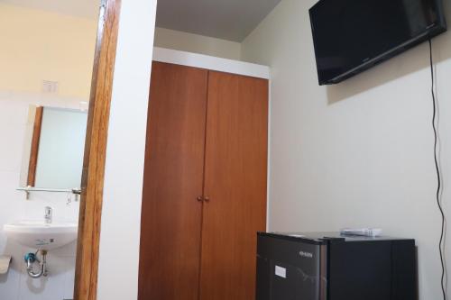 a bathroom with a wooden door and a sink at Anicia Guesthouse Rooms in Manila