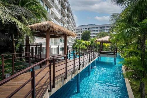 a resort swimming pool with palm trees and a building at laguna3 pattaya best pool room in Jomtien Beach
