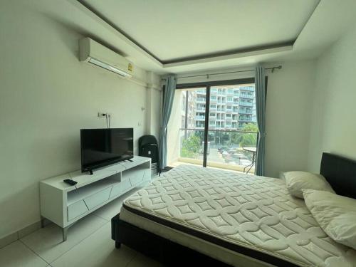 a bedroom with a bed and a television and a window at laguna3 pattaya best pool room in Jomtien Beach