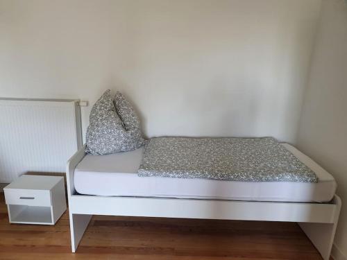 a bed with a white frame and a night stand at EG Weststadt Karlsruhe 4 Zimmer in Karlsruhe
