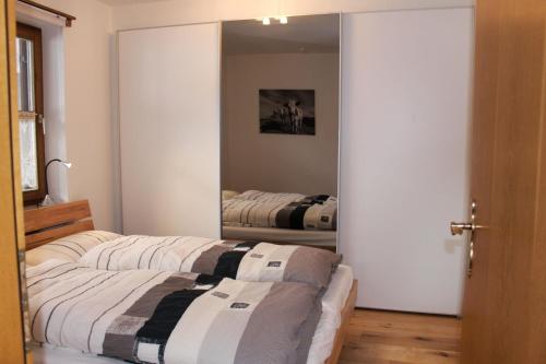 シュレヒングにあるFerienwohnung Geigelsteinblickのベッド2台と鏡のある寝室