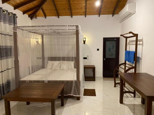 a bedroom with a bed with a mosquito net at See Turtle Villa in Tangalle