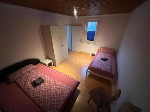 Habitación pequeña con 2 camas y silla en Siegen Achenbach 2 en Siegen