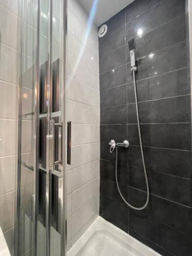 La salle de bains est pourvue d'une douche avec une porte en verre. dans l'établissement Le Tendance - Centre Historique, calme, WIFI, Netflix, à Niort
