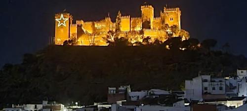 un castillo en la cima de una colina por la noche en Almodovar Alojamientos en Almodóvar del Río