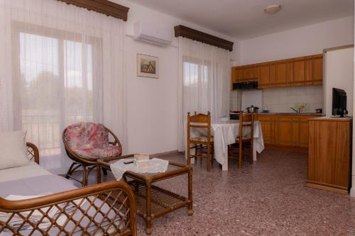 een woonkamer met een bank, stoelen en een tafel bij vickys family house in Stavros