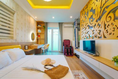 1 dormitorio con 1 cama con sombrero en Sanny Villas en Da Nang