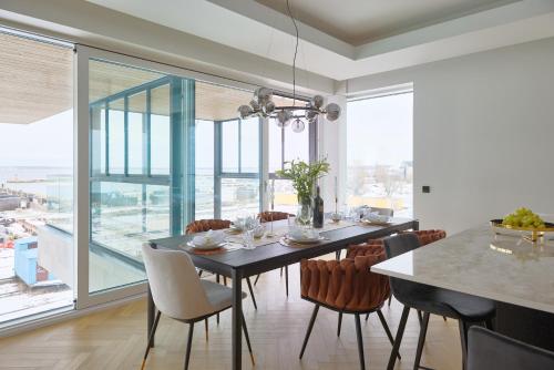 una sala da pranzo con tavolo, sedie e una grande finestra di 2023 Luxury Sunset Sea view apartement a Tallinn