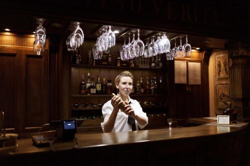a woman standing behind a counter in a bar at Hotel Adler in Byczyna