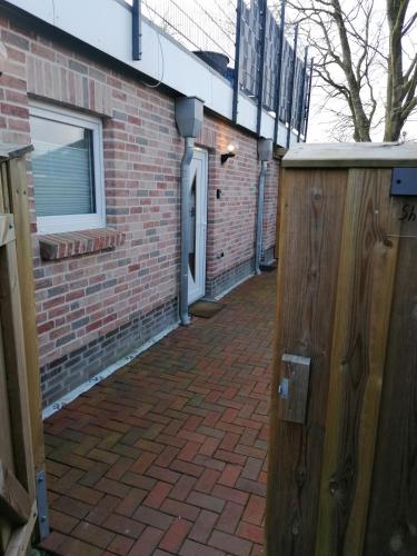 a brick building with a door and a brick sidewalk at Sharky Ferienwohnung in Bahnhofsnähe in Niebüll