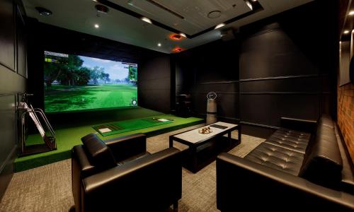 a movie room with a golf simulator with a green field at LOTTE Hotel Serviced Apartment in Yangon