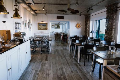 a restaurant with tables and chairs and a bar at Beachhotel Cuxhaven in Cuxhaven