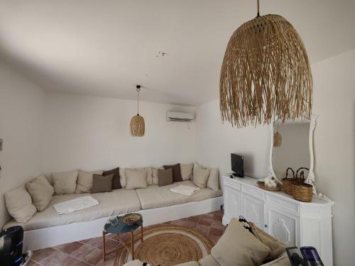 uma sala de estar branca com um sofá e um espelho em La Casa Di Aceste em San Vito lo Capo