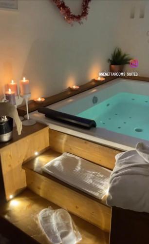 a pool in a room with two candles and a bed at Nenetta Rooms & Suites Monopoli in Monopoli