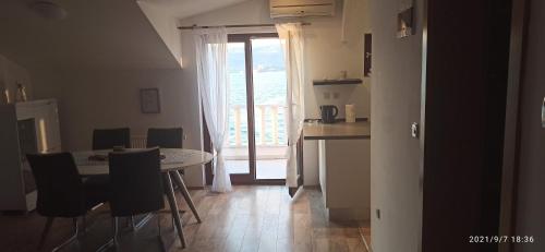 eine Küche und ein Esszimmer mit einem Tisch und einem Fenster in der Unterkunft Antonia Apartments in Trogir