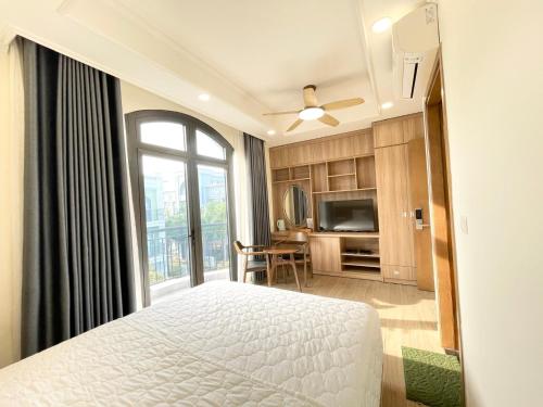 a bedroom with a bed and a large window at Cam Hotel Phu Quoc in Phú Quốc