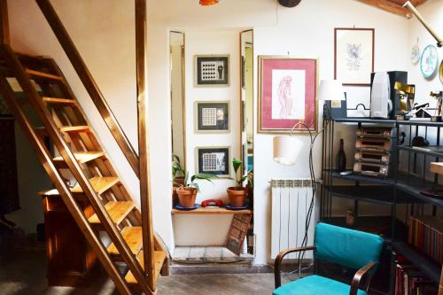 a room with a staircase and a blue chair at Casa Con Soppalco ad Ariccia in Ariccia