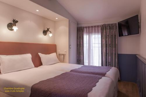 a bedroom with a bed and a window with a television at Hôtel Gaillon Opera in Paris