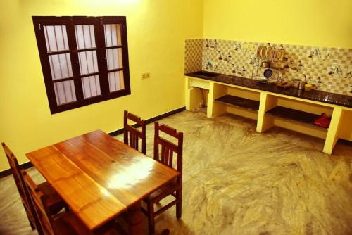 een eetkamer met een houten tafel en een tafel en stoelen bij Smith 5BHK Villa in Pondicherry