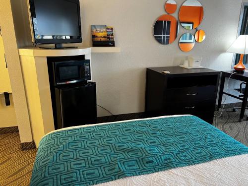 a hotel room with a bed and a flat screen tv at Howard Johnson by Wyndham Houston Heights Downtown in Houston