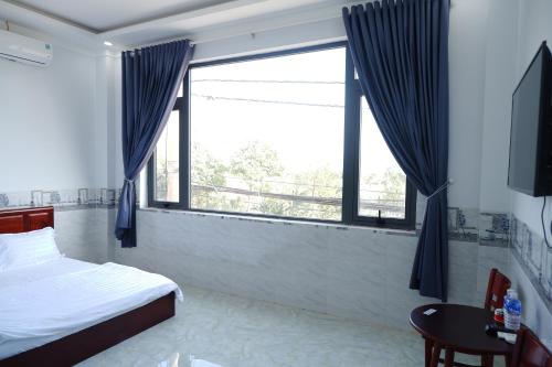 ein Schlafzimmer mit einem Bett und einem großen Fenster in der Unterkunft Thinh Khang Guesthouse in Buon Ma Thuot